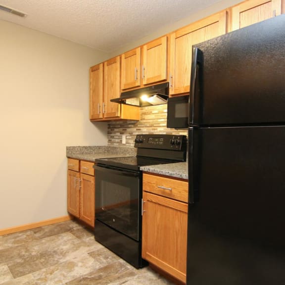 Thumbnail 5 of 27 a kitchen with black appliances and wooden cabinets