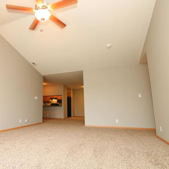 Thumbnail 9 of 27 a large empty living room with a ceiling fan