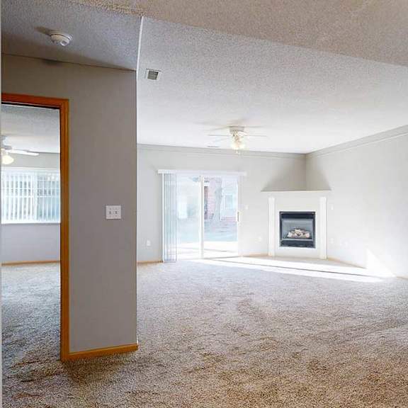Thumbnail 5 of 29 a living room with a fireplace and a ceiling fan