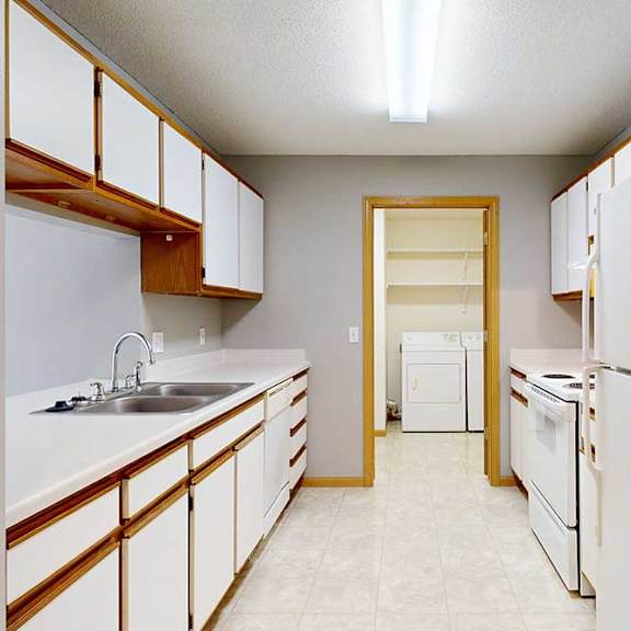 Thumbnail 3 of 29 A kitchen with white appliances and wooden cabinets.