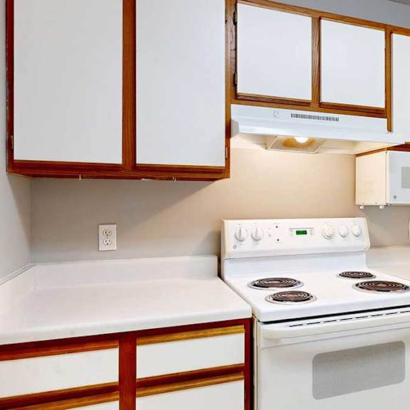 Thumbnail 19 of 29 a white stove and oven in a kitchen with white cabinets and a white refrigerator