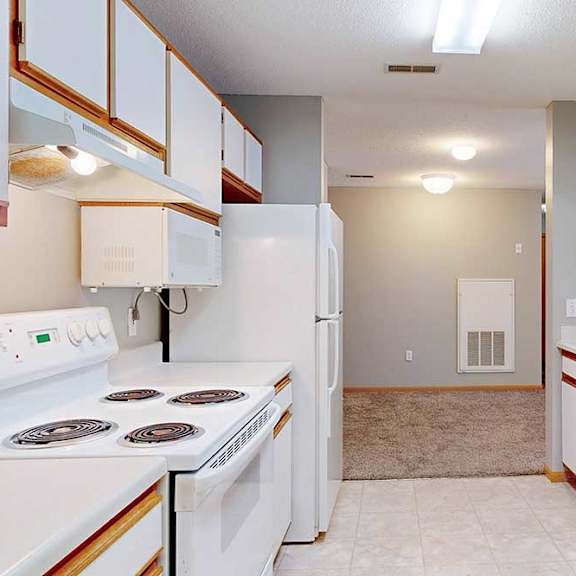 Thumbnail 16 of 29 a galley-style kitchen with white appliances and cabinets