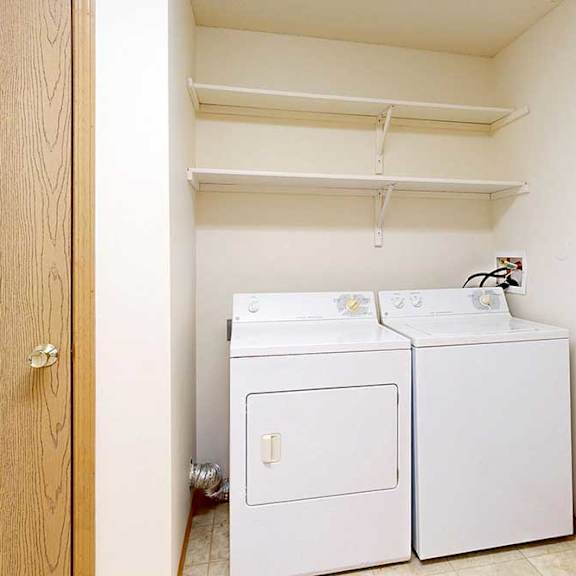 Thumbnail 21 of 29 A small laundry room with a washer and dryer.