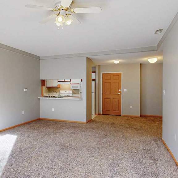 Thumbnail 7 of 29 A room with a ceiling fan and a carpeted floor.