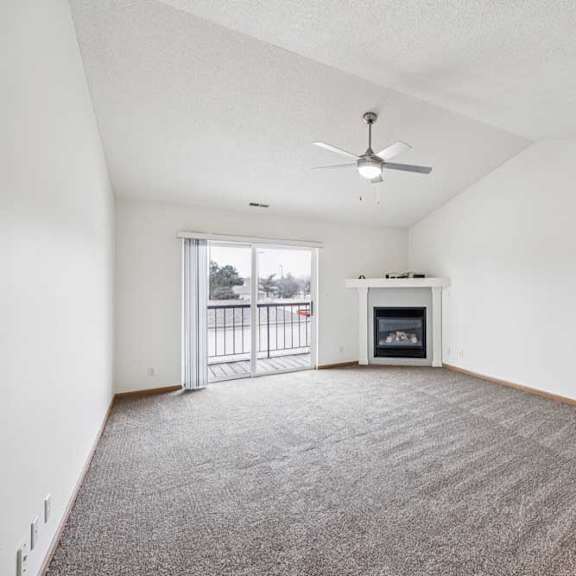 Thumbnail 23 of 29 A room with a fireplace and a ceiling fan.