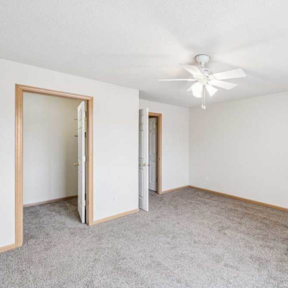 Thumbnail 19 of 28 A room with a ceiling fan and carpeted floor.