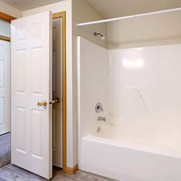 Thumbnail 16 of 31 a bathroom with a white tub and shower combo with chrome fixtures