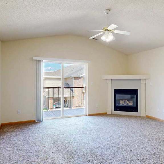 Thumbnail 28 of 31 a living room with sliding glass door, gas fireplace, and ceiling fan