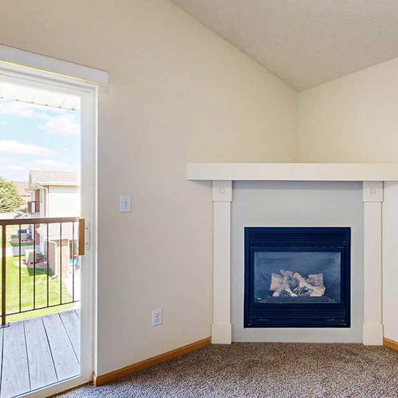 Thumbnail 23 of 31 a close up of a gas fireplace with mantle in a carpeted living room with a sliding glass door