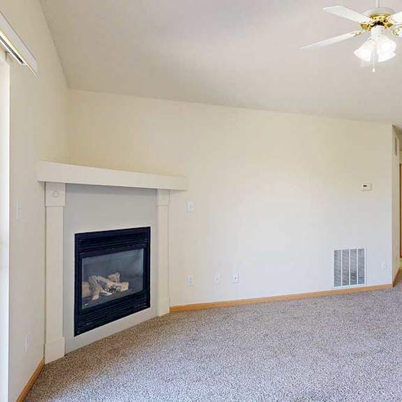 Thumbnail 22 of 31 a living room with a gas fireplace, vaulted ceiling, and ceiling fan