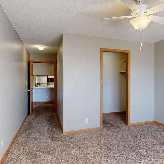 Thumbnail 27 of 61 bedroom and walk in closet with a ceiling fan and carpeted floor.