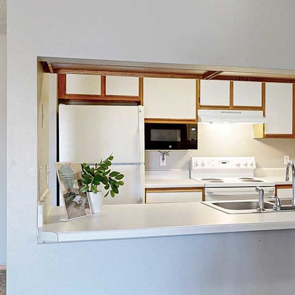Thumbnail 24 of 27 a kitchen with a sink, stove, and microwave.