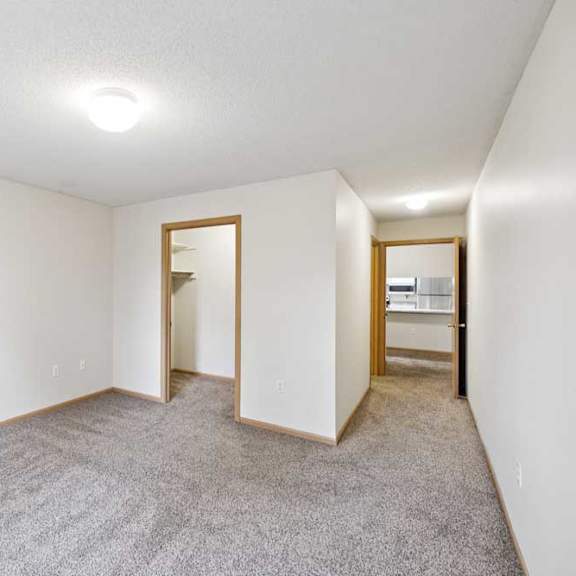 Thumbnail 45 of 56 A room with a carpeted floor and a doorway leading to another room.