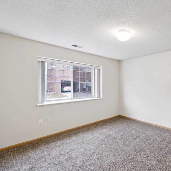 Thumbnail 44 of 56 A room with a carpeted floor and a window.
