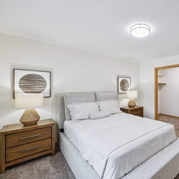 Thumbnail 31 of 56 A bedroom with a large bed and two nightstand with lamps, and attached walk-in closet