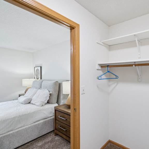 Thumbnail 32 of 56 Large walk-in closet with empty shelving and door to bedroom