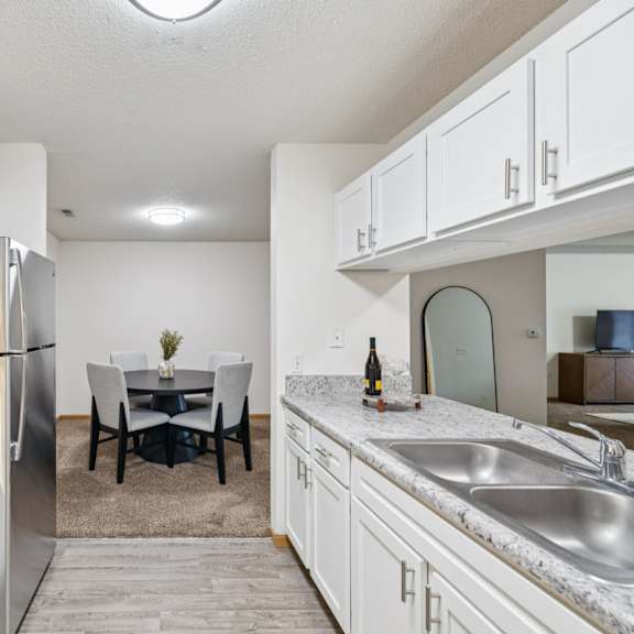 Thumbnail 22 of 56 A kitchen with white cabinets and stainless steel appliances