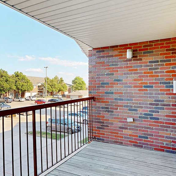 Thumbnail 22 of 29 a balcony with a brick wall and a metal railing