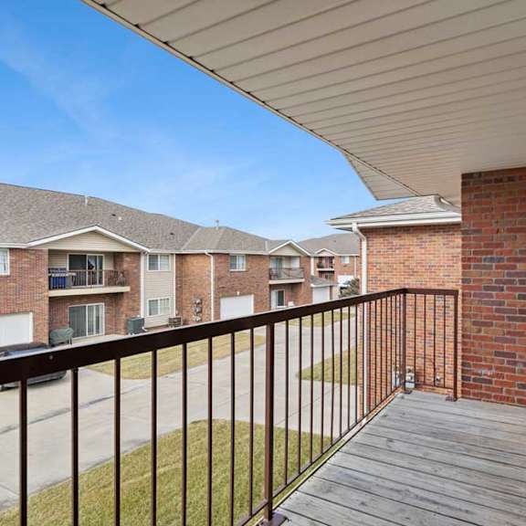 Thumbnail 36 of 48 A balcony with a black railing and a brick wall.