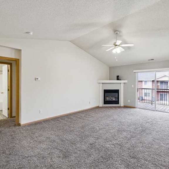 Thumbnail 30 of 48 A spacious living room with a fireplace and sliding glass doors.