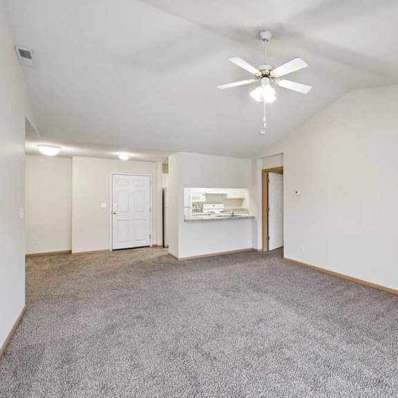 Thumbnail 43 of 48 A spacious living room with a ceiling fan and carpeted floor.