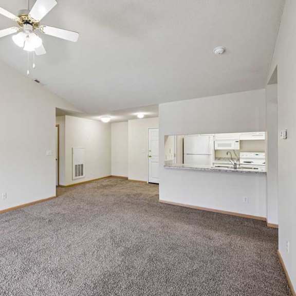 Thumbnail 37 of 48 A spacious room with a ceiling fan and carpeted floor.