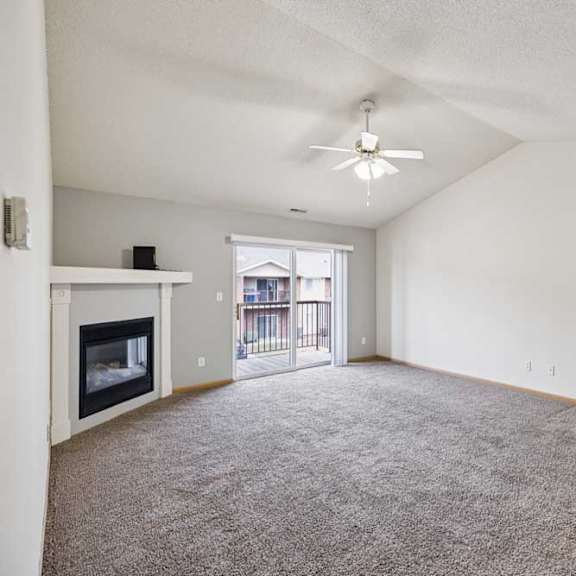 Thumbnail 32 of 48 A spacious living room with a fireplace and carpeted floor.