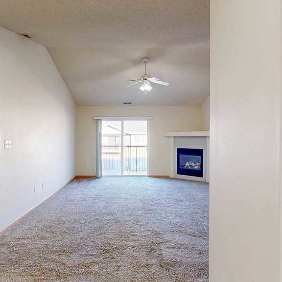 Thumbnail 5 of 28 A spacious living room with a carpeted floor and a ceiling fan.