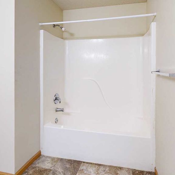 Thumbnail 16 of 28 A white bathtub with a shower head and faucet.