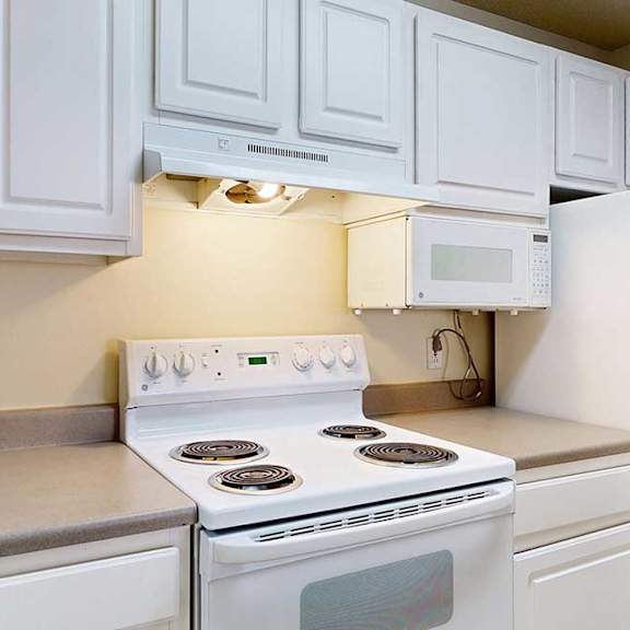 Thumbnail 2 of 28 A white stove and oven in a kitchen with white cabinets.