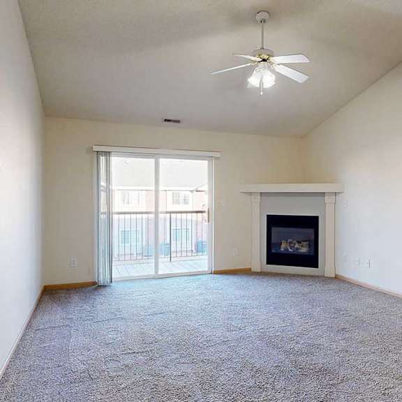 Thumbnail 10 of 28 a living room with a fireplace and sliding glass doors