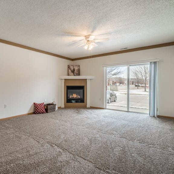 Thumbnail 6 of 17 a living room with a fireplace and a door to a patio