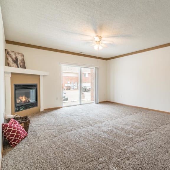 Thumbnail 8 of 17 a living room with a fireplace and a carpeted floor