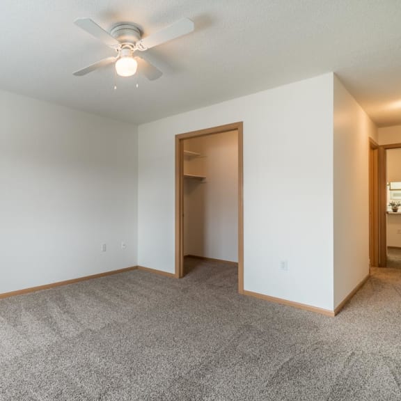 Thumbnail 10 of 17 an empty living room with a ceiling fan and a closet