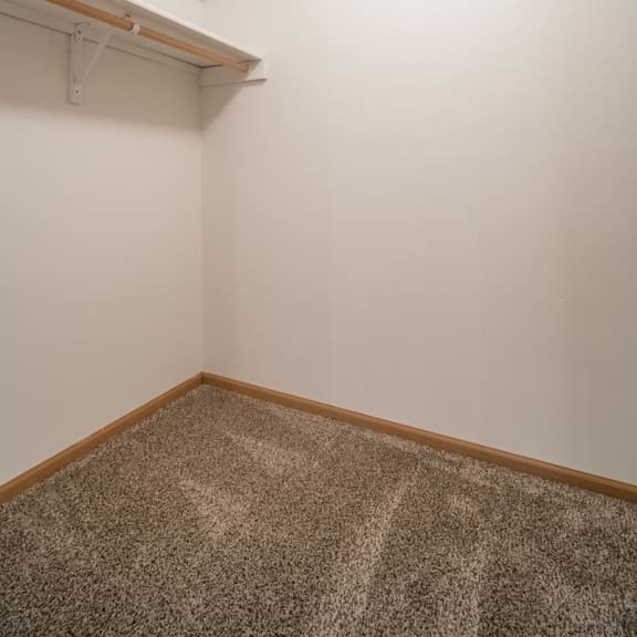 Thumbnail 11 of 17 a room with a carpeted floor and a white wall