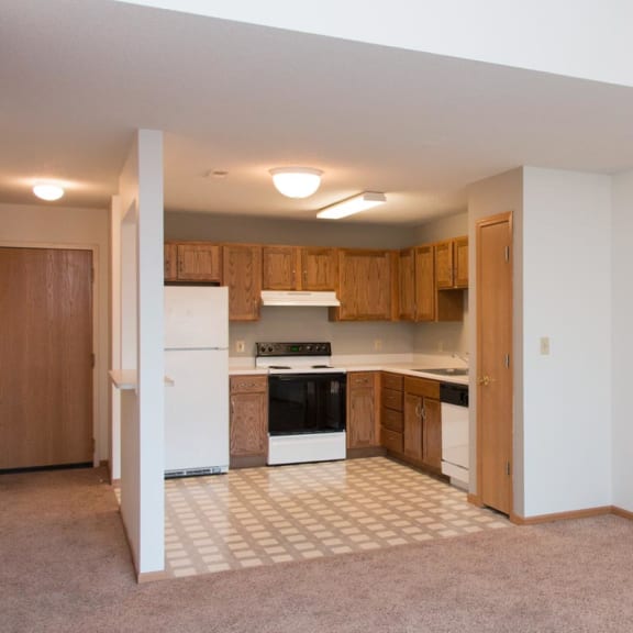 Thumbnail 3 of 16 an empty kitchen with white appliances and wooden cabinets