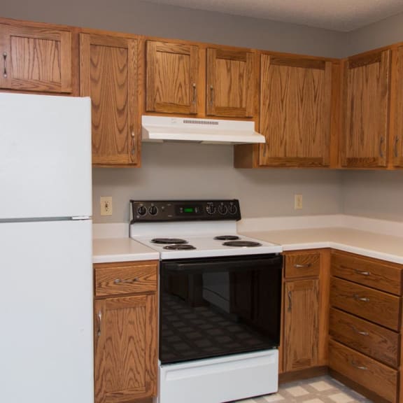 Thumbnail 4 of 16 a kitchen with a stove and a refrigerator