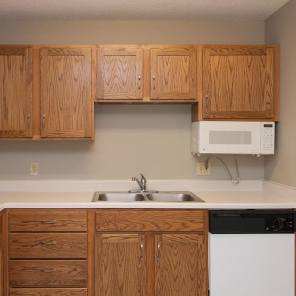 Thumbnail 5 of 16 a kitchen with wooden cabinets and a stove and a sink