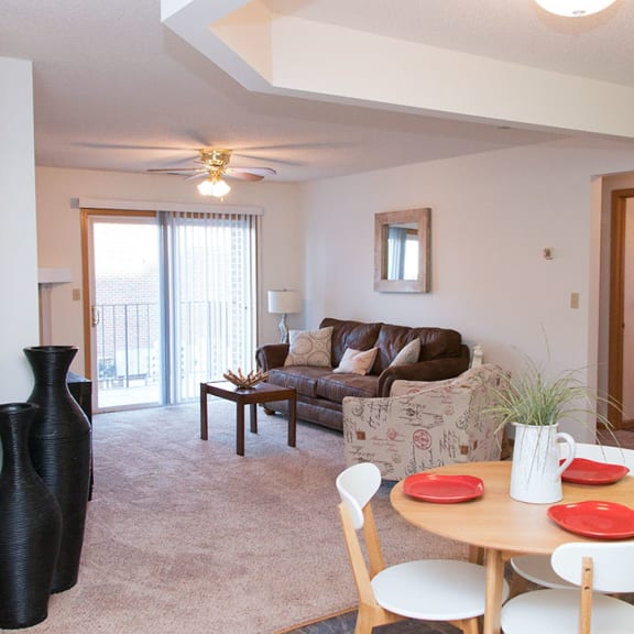 Thumbnail 2 of 7 a living room with a dining room table and a couch
