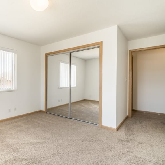 Thumbnail 6 of 11 an empty bedroom with a mirrored closet door