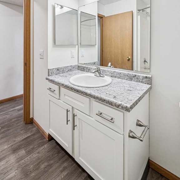 Thumbnail 15 of 18 A bathroom with white cabinet vanity, oversized mirror with overhead lighting, and a medicine cabinet.