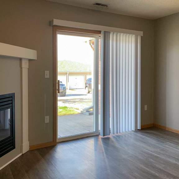 Thumbnail 10 of 21 a living room with a fireplace and mantle next to a sliding glass door