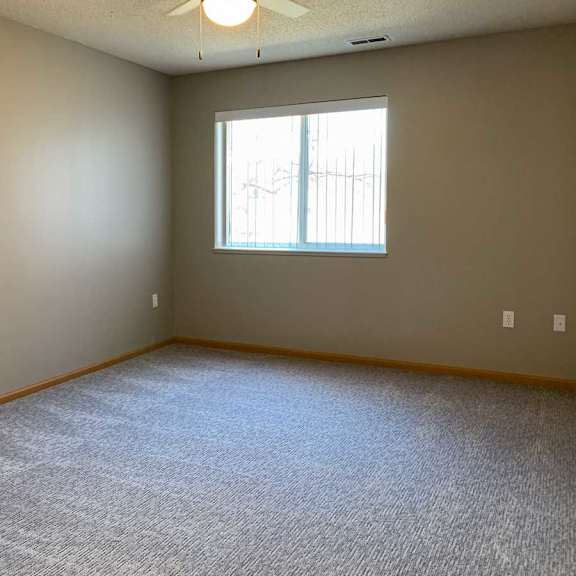 Thumbnail 15 of 21 a bedroom with carpeted flooring, a large window, and a ceiling fan