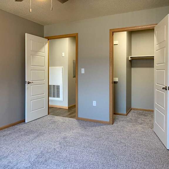 Thumbnail 14 of 21 a carpeted bedroom with a walk-in closet