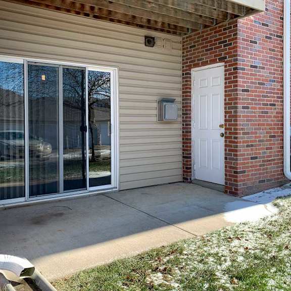 Thumbnail 11 of 21 a patio off a brick building with a sliding glass door