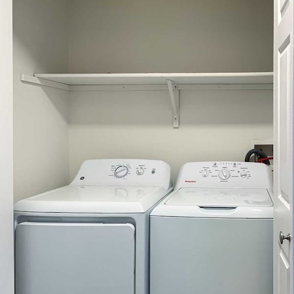 Thumbnail 15 of 16 a laundry closet with side-by-side full-sized washer and dryer with overhead shelving