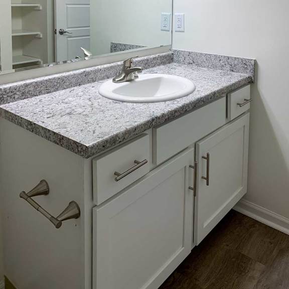 Thumbnail 14 of 16 a bathroom with a white vanity sink with granite countertops and overhead lighting