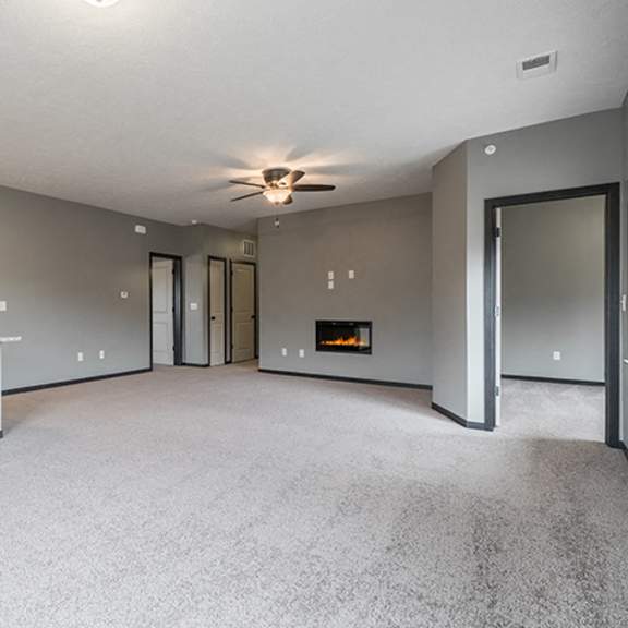 Thumbnail 5 of 11 Living room with electric fireplace and ceiling fan at The Villas of Omaha at Butler Ridge in Omaha Nebraska