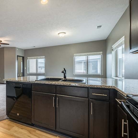 Thumbnail 7 of 11 A kitchen that opens up to a large living space at the Villas of Omaha at Butler Ridge in Omaha Nebraska