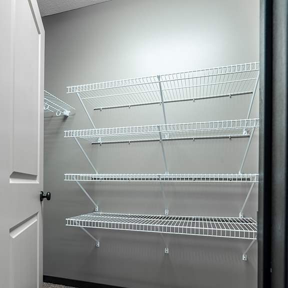 Thumbnail 10 of 11 Empty walk-in closet with shelves and carpeted floor.
